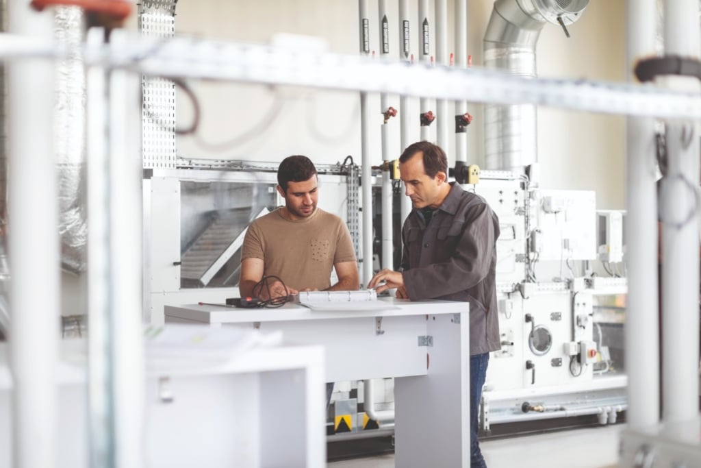 un apprenant et un formateur dans un atelier pour des mises en situations sur le froid, le chaud, le traitement de l'air, le gaz