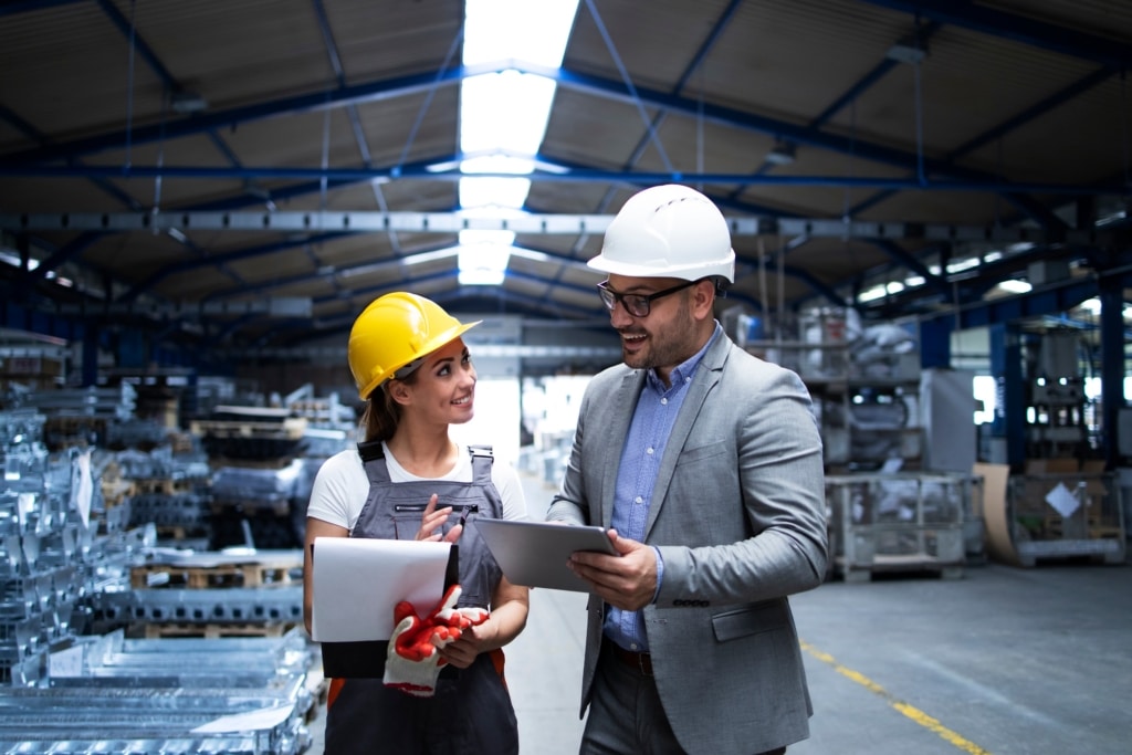 2 personnes dont l'un est manager, l'autre collaborateur en équipement de protection industriel en train d'échanger dans une usine de production